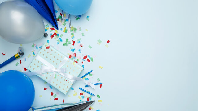 Concept of festive birthday celebrations. Birthday attributes colorful balloons, party hats, candles, confetti