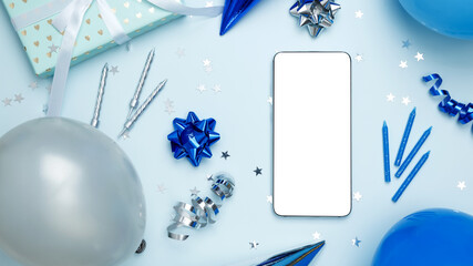 Concept of celebration and technology. Smartphone with blank screen surrounded by balloons, gifts, and party decorations