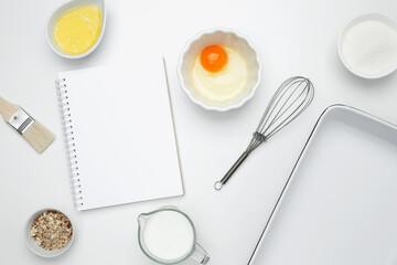 Open white notebook with baking ingredients for Crinkle Cake, including butter, milk, sugar, egg, nuts