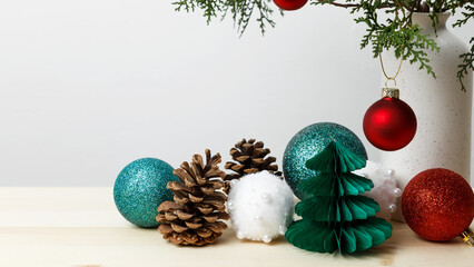 Christmas ornaments arranged for festive decoration, vase with thuja branches, pinecones