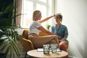 Female psychologist smiling while having a therapy session with a client in her office