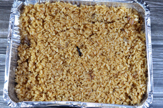 Cooked white Egyptian rice by hot steam and gained the brown color from onions, cooked with seafood cuisines, fish and shrimps, Middle Eastern food concept, Egyptian cuisine background
