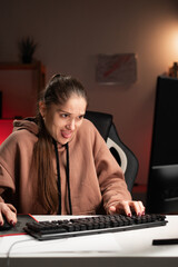 Female programmer working at home at night with displeased expression expressing disgust sitting at...