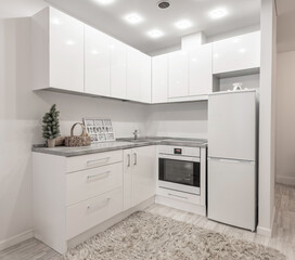 Fototapeta premium Modern Minimalist Home Kitchen Interior with White Cabinets and Warm Decorative Elements. Scandinavian Style