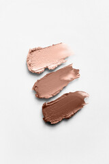 Demonstrating color of the year 2025. Mocha mousse color swatch. Cosmetic smears on white background. Lipstick or lip gloss swatch macro wallpaper. Beauty swash texture.
