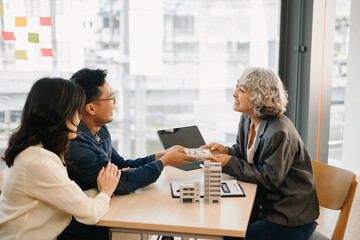 Fototapeta premium A family couple sign a lease meeting with a realtor or homeowner, purchase the first mortgage and mortgage ownership concept.