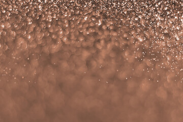 Brown, mocha mousse sparkling glitter bokeh background, abstract defocused texture. Holiday lights. Demonstrating color, trend 2025 year