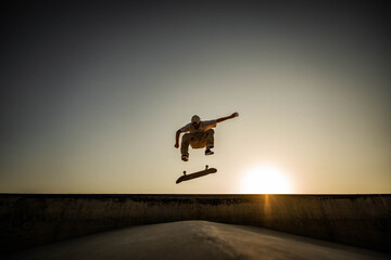 Skater doing kickflip on the ramp at skate park - Stylish skaterboy training outside - Extreme...