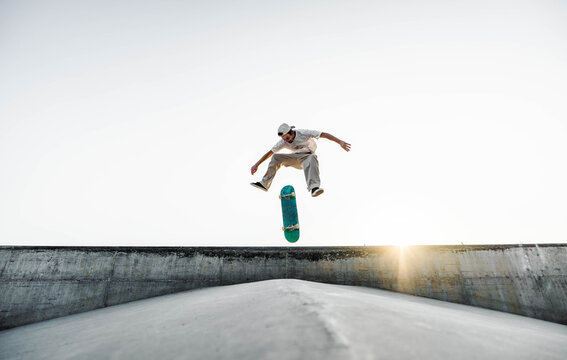 Skater doing kickflip on the ramp at skate park - Stylish skaterboy training outside - Extreme sport life style concept