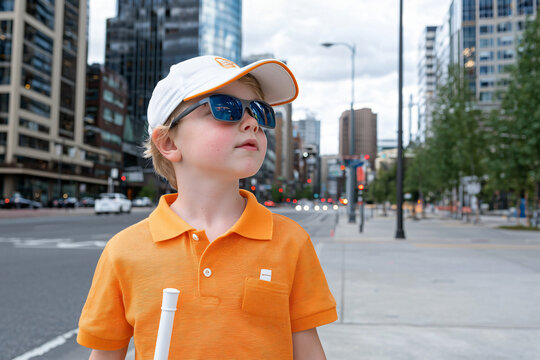 visually impaired child confidently navigating urban sidewalk with white mobility cane