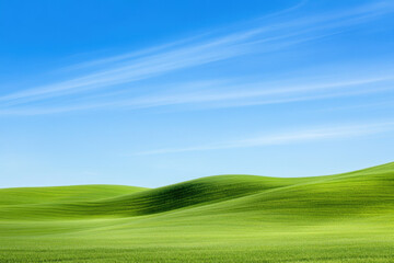 Obraz premium Serene green hills under clear blue sky with wispy clouds