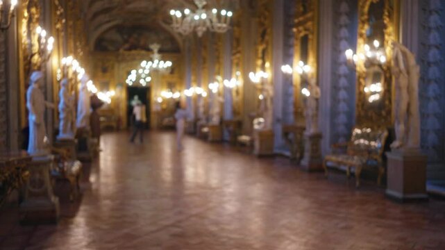 Blurry woman in galleria doria pamphilj surrounded by statues and ornate decor with soft lighting and elegant chandeliers in a luxurious museum setting.