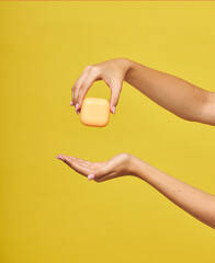 Woman s Hands Holding Orange Soap Bar over Yellow Background