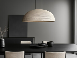 Minimalistic dining area with a large black table and woven pendant lamp. Wooden chairs with woven seats complement the simple and elegant design.