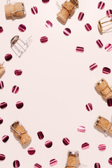 Champagne corks and glittering confetti wih sunlight shadows, star filter flare, Trend aesthetic flat lay, holidays, celebration pattern. Bottle cork and muselet on pastel color table, copyspace