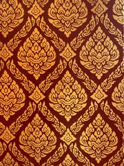 Golden Thai pattern background on the red wall of a beautiful Thai temple.