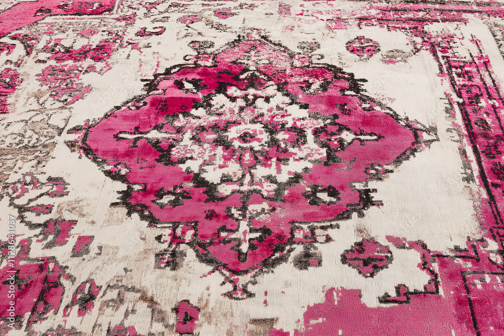Poster a faded rug in soft pink and cream tones with intricate vintage patterns.