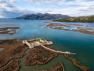 Aerial view of the historic Ali Pasha Castle surrounded by serene waters and mountains. Albania