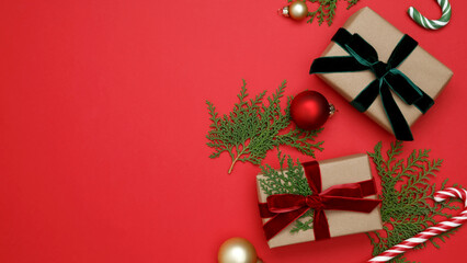Christmas ornaments, gifts wrapped in craft paper,  thuja branches, candy cane arranged