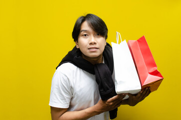 Happy Surprised Young Asian Man Holding Shopping Bags in Excitement