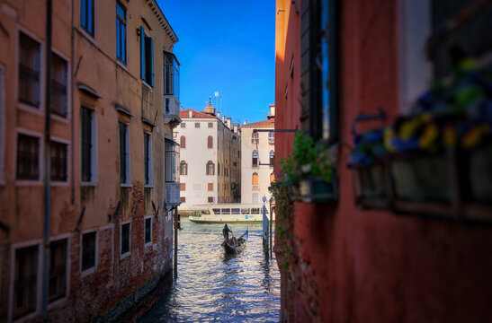 Picturesque canal in Venice with a gondola navigating through narrow passageways