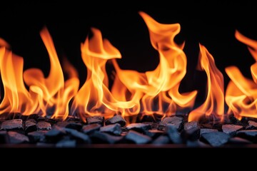Fototapeta premium A row of fire with orange flames and black rocks