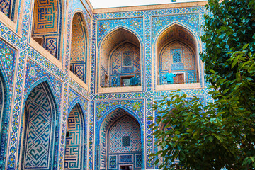 Obraz premium Woman in blue traditional clothing in the courtyard of the Ulugbek Madrassah.