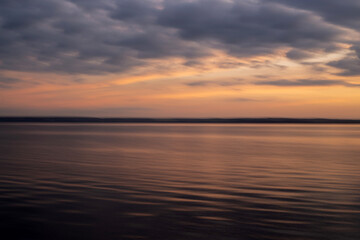 colorful background of the sunset on the sea, the horizon is a calm sky