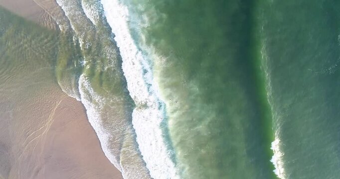 aerial drone zenithal of a beach, waves foam on the shore. Marine background concept