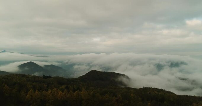Timelapse of hypnotizing view from the top of a observation tower showing hills of Bohemian Uplands with mist evaporating from forrests rolling in valleys and layer of stratus clouds flying in the sky