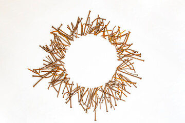 Fototapeta premium Round frame made of rusty bent nails on white background