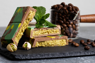 Close up Dubai chocolate bar with green kadaif and peanut butter on black stone stand