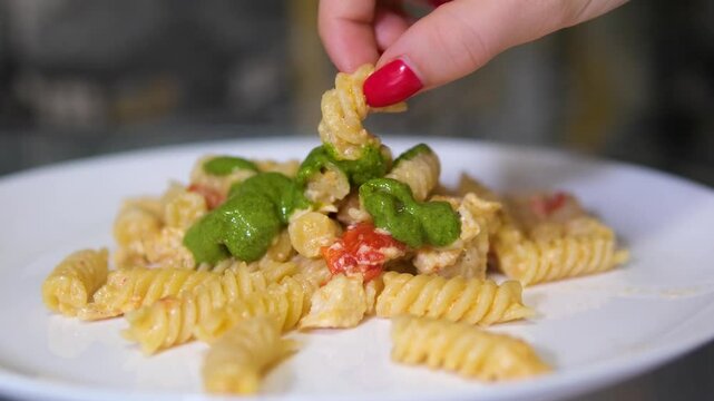 Serving pasta with pesto and stracciatella cheese in restaurant. Italian cuisine dish.