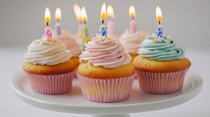 Delicious birthday cupcakes with burning candles on white background