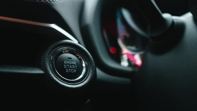 Close-up of a car start button being pressed by a woman. Concept of modern technology, convenience, and innovation in cars.