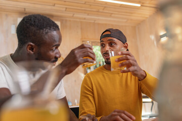Two African American LGBT gay men talking about tasty breakfast food, the glamping restaurant...
