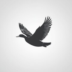 Obraz premium Silhouette of a duck in flight against a light gray background.