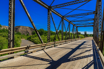 Fototapeta premium A bridge with a view of a forest and a mountain in the background