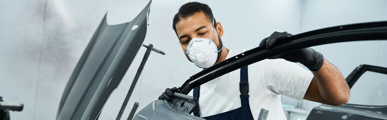 Skilled young mechanic carefully inspects car components in a bright workshop setting.