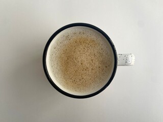 Top View of a Frothy Coffee in a Minimalist Speckled Mug on White Background