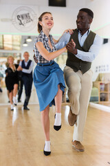 Fototapeta premium Man and woman performing jazz dance in dancing room