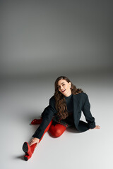 A stylish woman playfully stretches, showcasing her vibrant fashion choices.