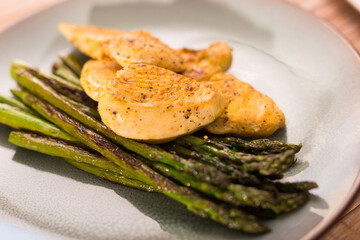 Dietary meal rich in protein. Stir fried chicken breast and green asparagus