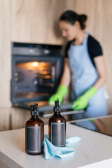 Woman cleaning an oven in a modern kitchen while preparing for housework