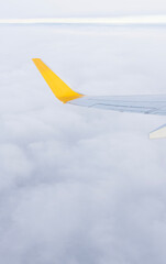 A high-resolution photo of a plane wing and blue sky viewed through an airplane window, symbolizing aviation, travel, vacations, and early booking opportunities.