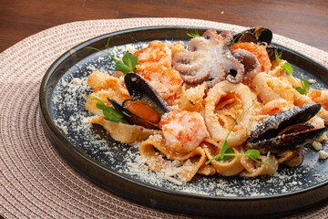 Tagliatelle with seafood in tomato-cream sauce. This Italian-inspired dish offers a delightful combination of textures and flavors from the sea.