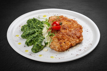 Chicken schnitzel served with sauce, accompanied by broccoli and cheese fritters.