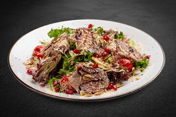 A fresh salad featuring tender veal, juicy cherry tomatoes, and crunchy pomegranate seeds.