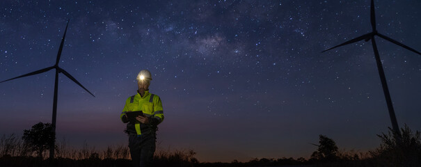 Survey Team Alternative energy for future at night for inspector safety.  Engineers survey and checking wind turbines at milky way background. Wind Turbine Renewable energy technology © kanpisut