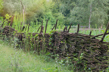 Traditional wooden farmhouse. Aged wooden fence in countryside. Village ethnographic museum. Vintage exterior.